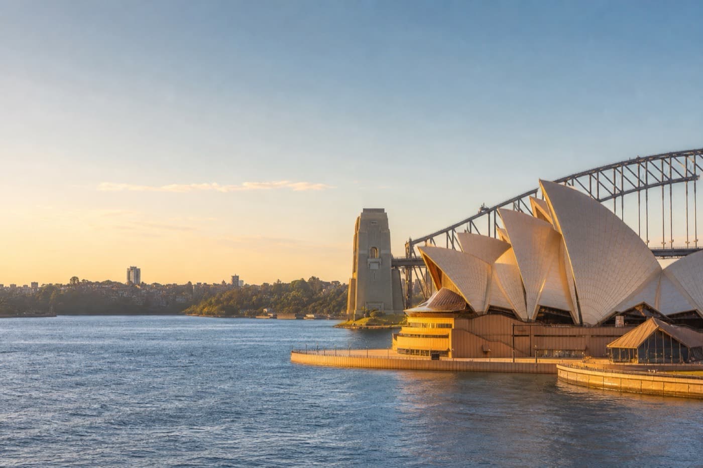 Sydney Harbour with Opera House sails and waterfront in golden afternoon light, Australia