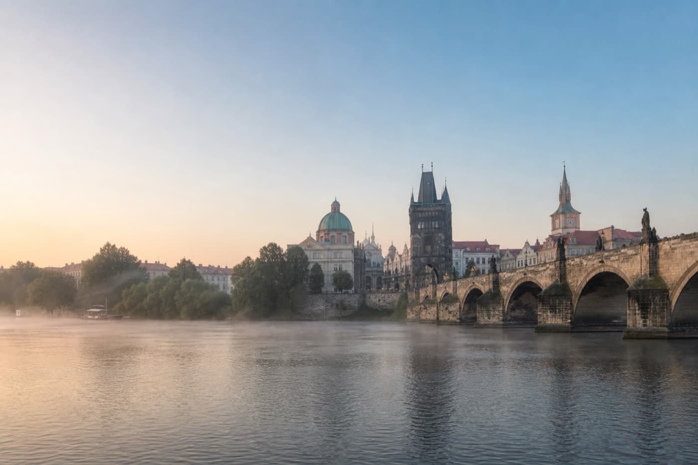 Prague historic rooftops and river bridges in gentle morning light, Czech Republic