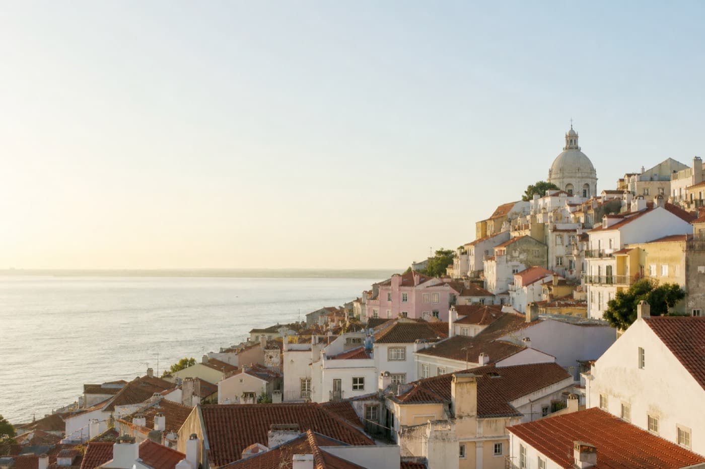 Lisbon hillside rooftops and the Tagus River under soft morning light, Portugal