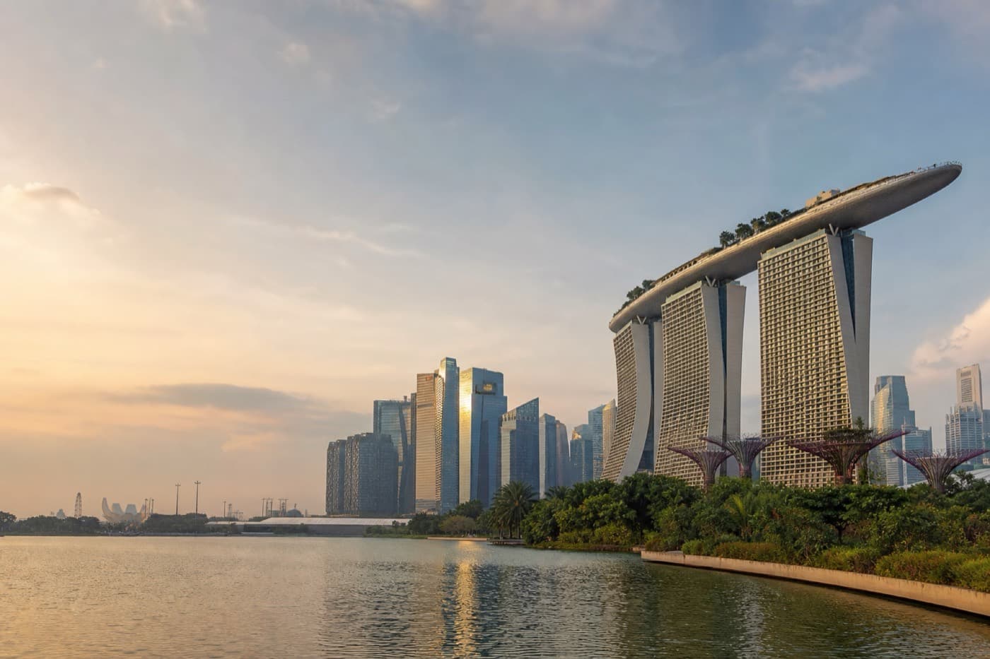 Singapore Marina Bay skyline and tropical waterfront gardens at dusk, Singapore
